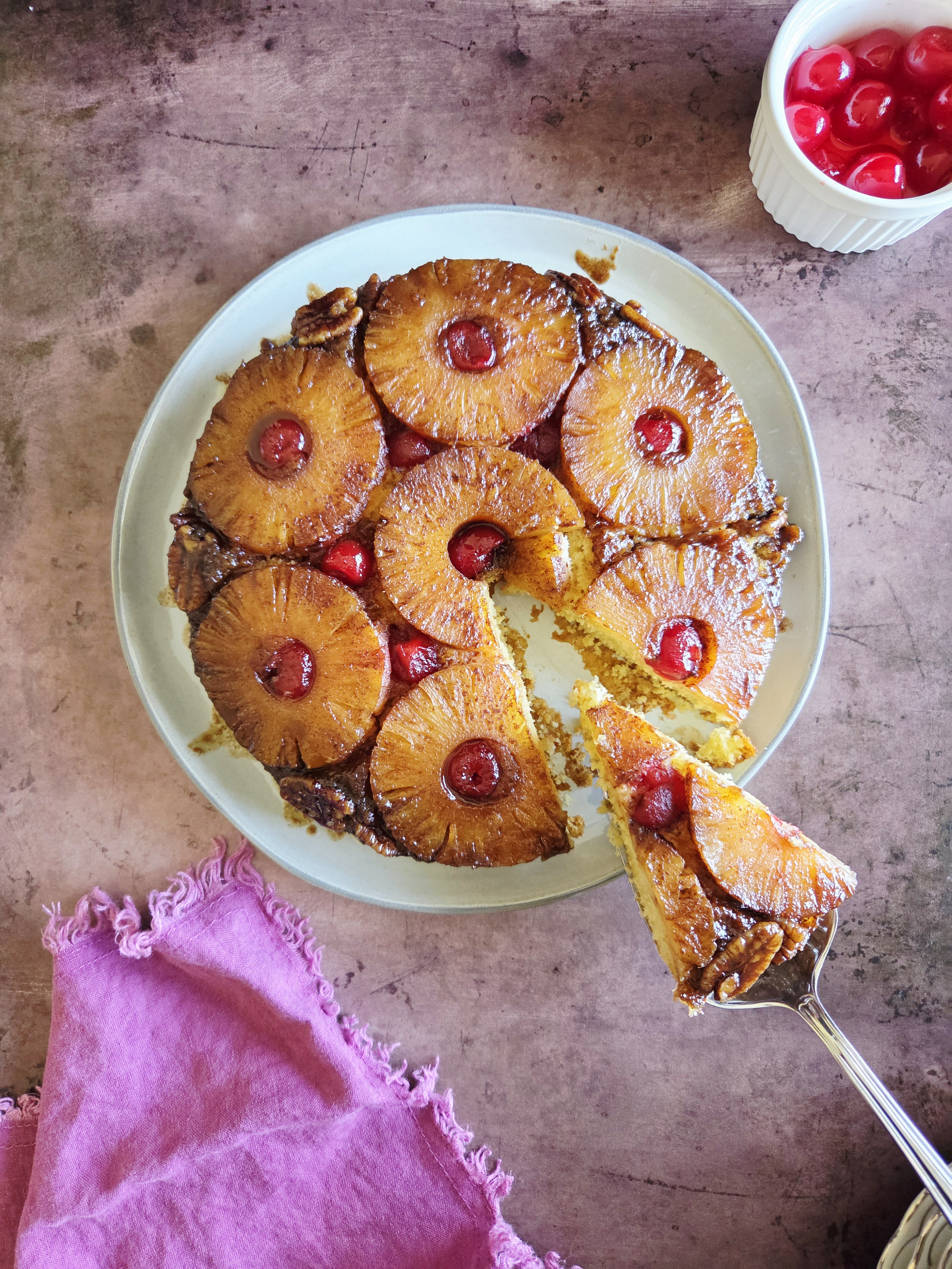 pineapple upside down cake with cherries on platter